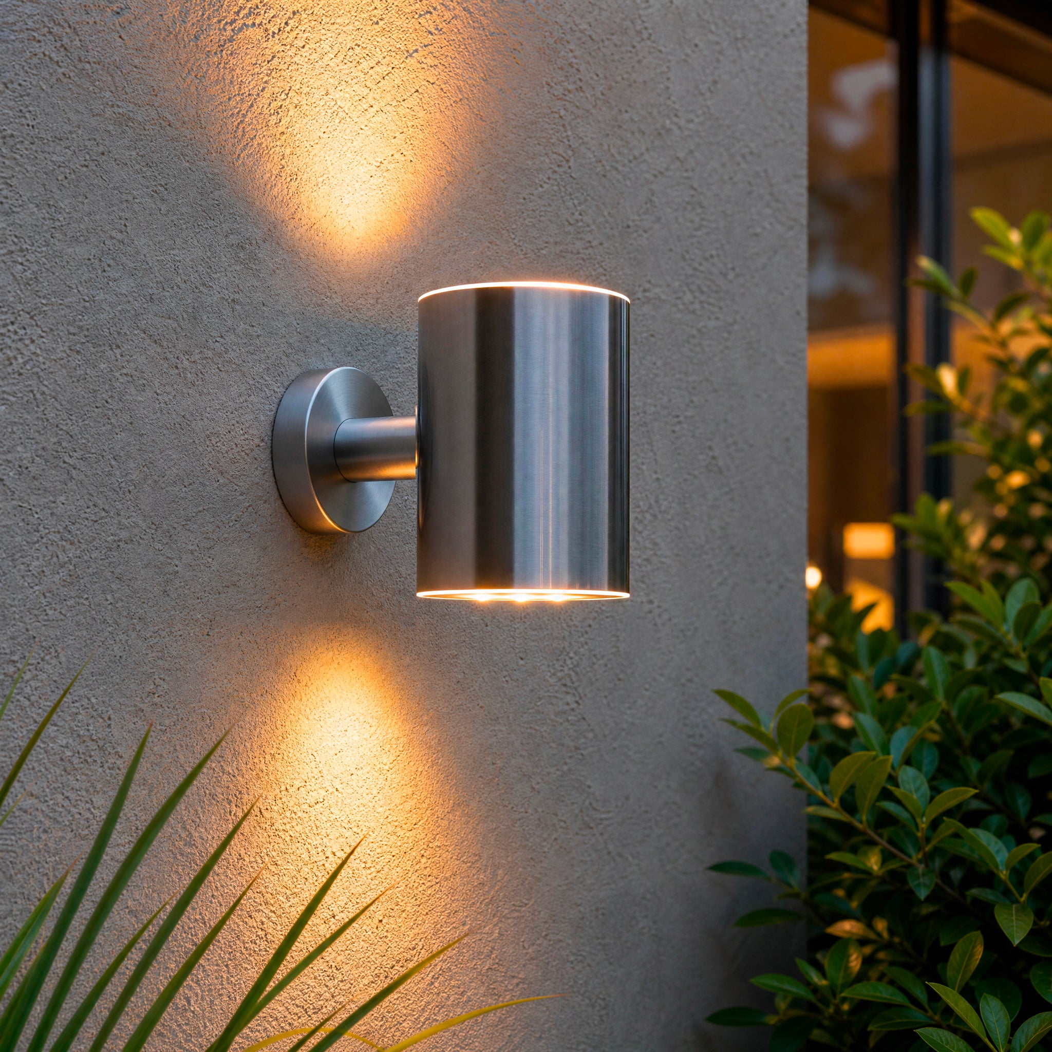Modern outdoor wall light fixture on a textured wall with plants around